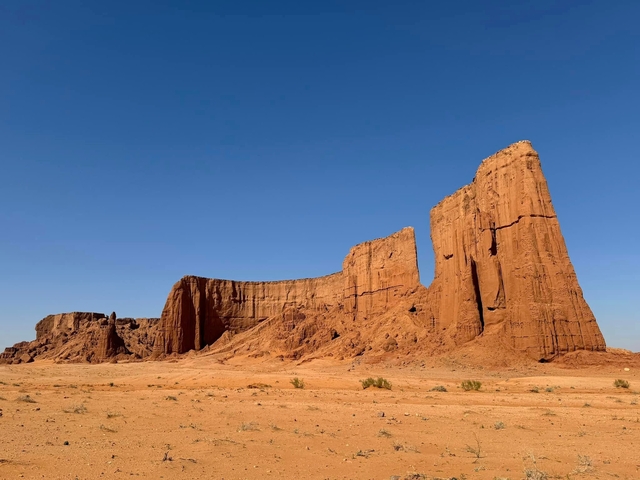 Red rock formations standing tall under a blue sky.