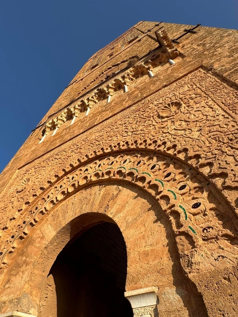       Detailed stone carving on a historical building under blue sky.
  