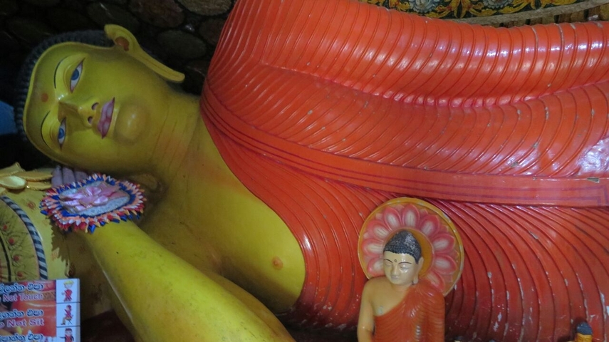Reclining Buddha statue in a temple with vibrant colors.