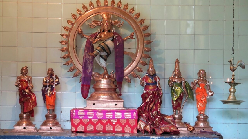 Religious statues in a temple with tile background.