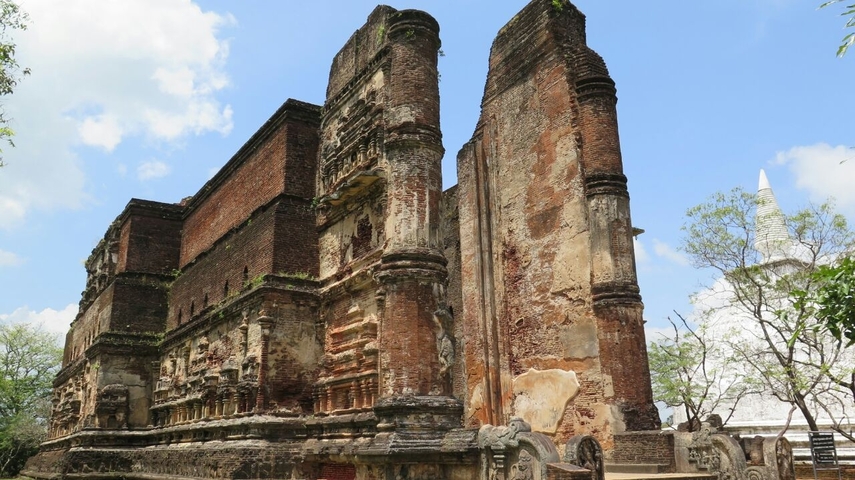 Ruins of an ancient brick and stone building under a clear sky.