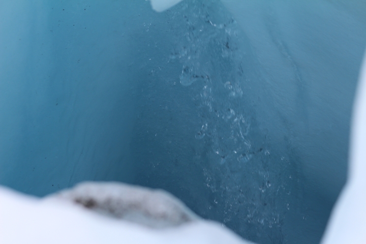       Close-up of water flowing down an ice crevice.
  