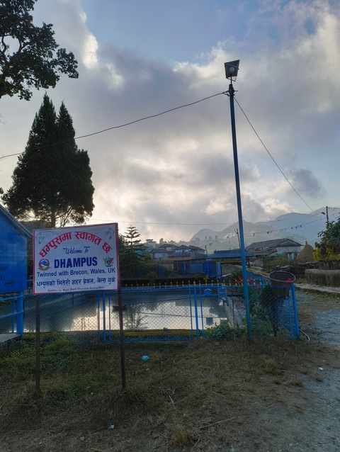       Sign and surroundings of a town in Dhampus.
  