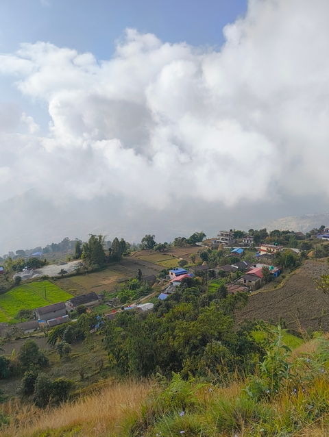 Aerial view of a village surrounded by fields and hills.