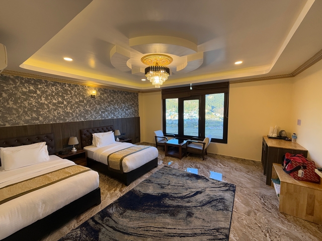 Hotel room with twin beds and a mountain view.