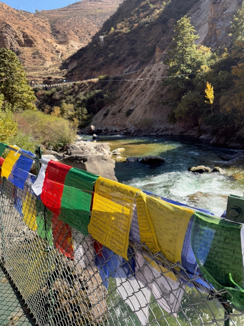       Colorful prayer flags above a river.
  
