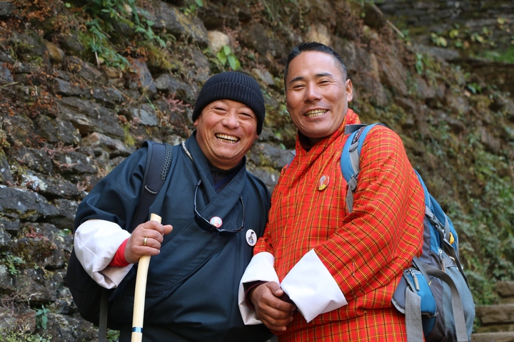       Two people posing and smiling in outdoor attire.
  