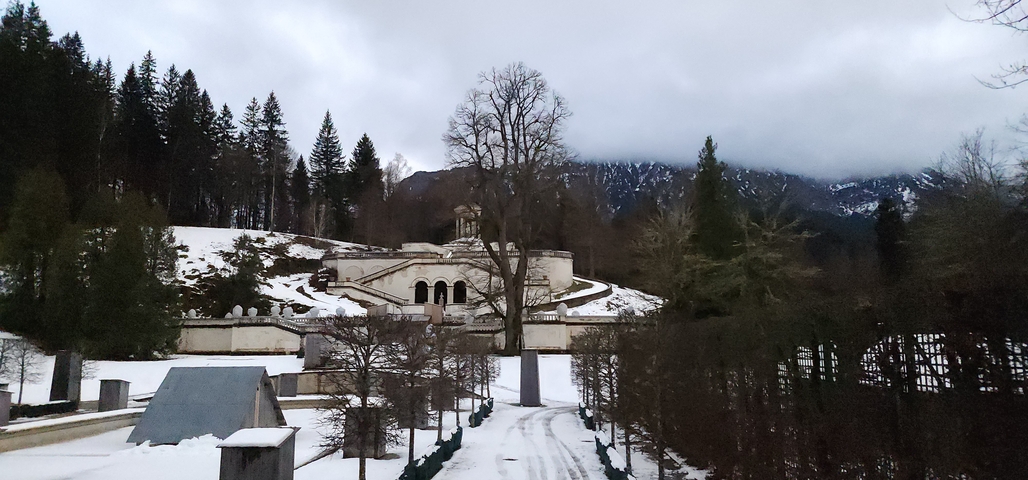       Snow-covered park with a historical building in the background.
  