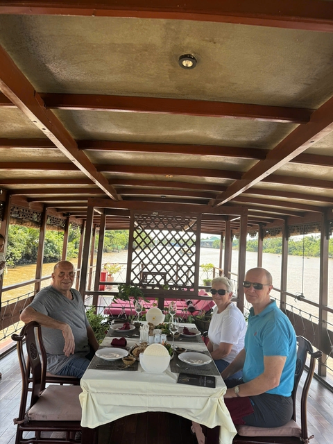 People sitting on a boat with a river view.