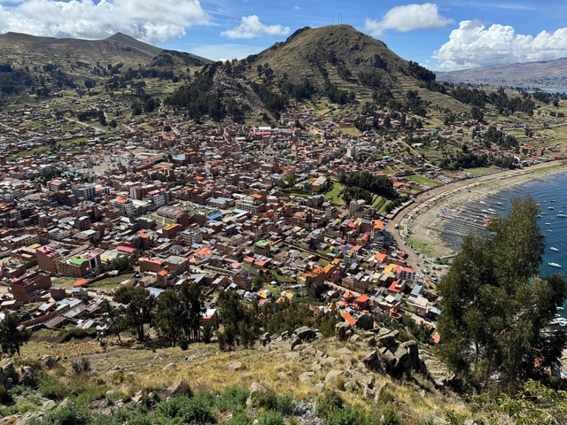 Scenic view of a colorful town nestled between a hillside and a lake.