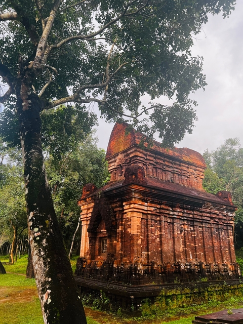 Ancient temple ruins surrounded by trees with distinct, intricate carvings.