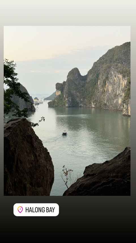 A serene view of a narrow boat navigating a calm river flanked by towering cliffs.