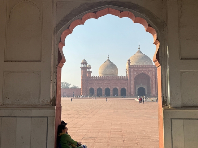       A large mosque viewed through an archway.
  