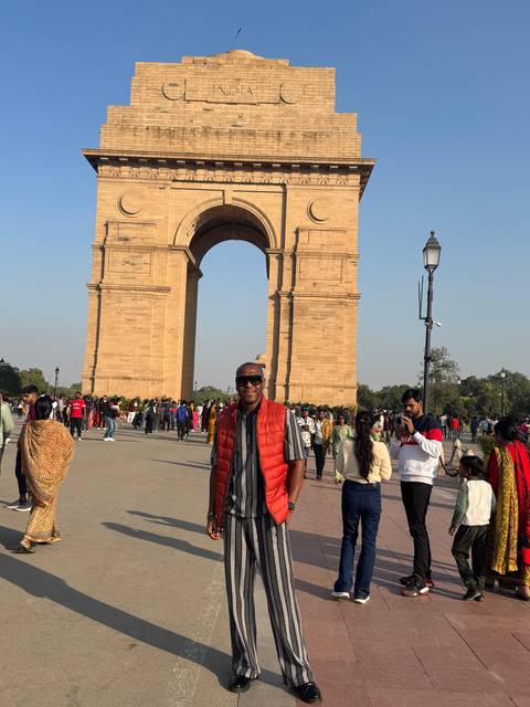       Man standing in front of India Gate.
  