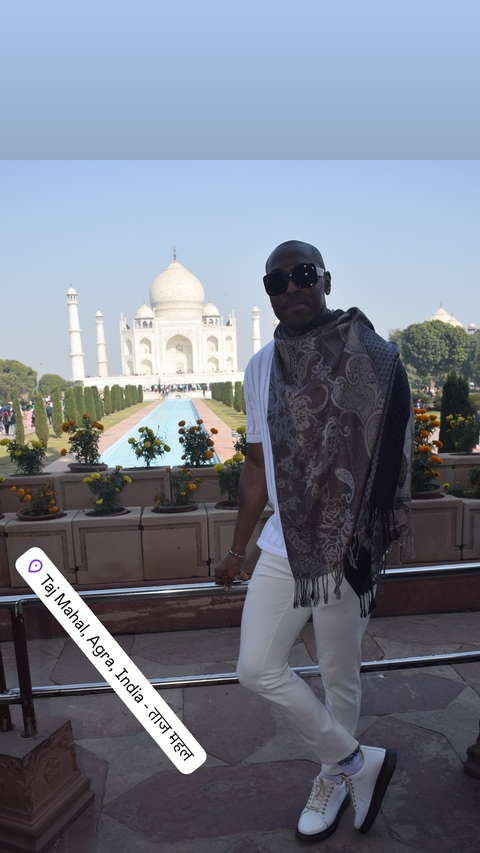       Man at the Taj Mahal with a reflection pool.
  