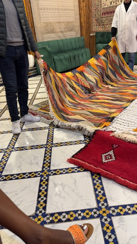 Close-up of a person showcasing a colorful rug.