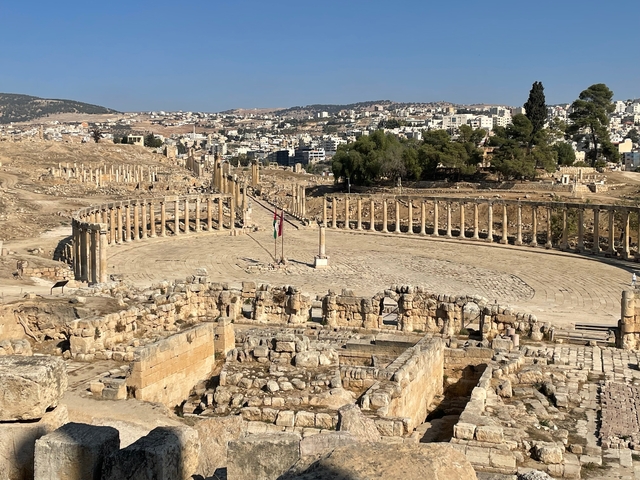 Roman ruins with a large colonnaded oval plaza.