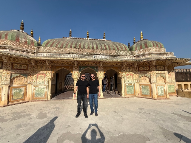 Two men standing in front of an ornate building with domes.
