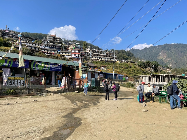 Busy marketplace with people and hillside buildings.