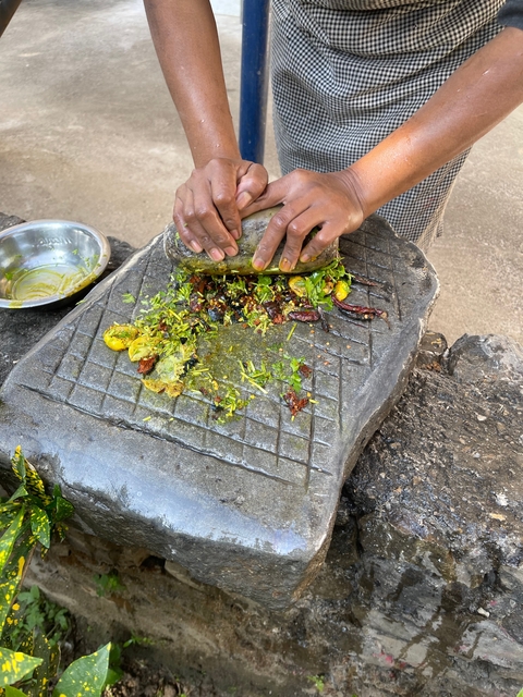 Hands preparing food with fresh ingredients on a stone surface.