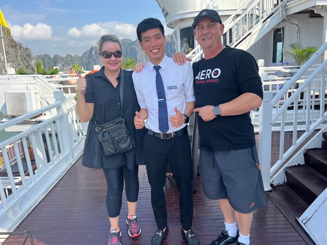      Three people posing for a photo on a boat.
  