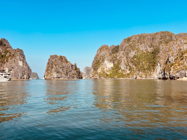       Scenic view of limestone cliffs and calm water under a clear blue sky.
  
