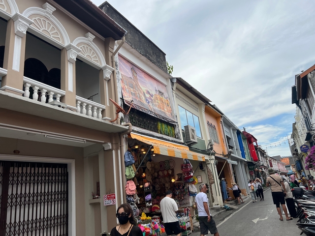       Bustling street with colorful shops and tourists.
  
