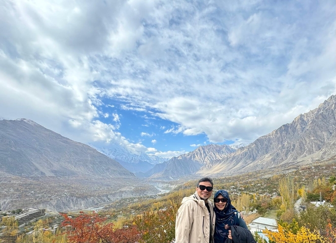 Couple posing in a scenic valley with mountains.
