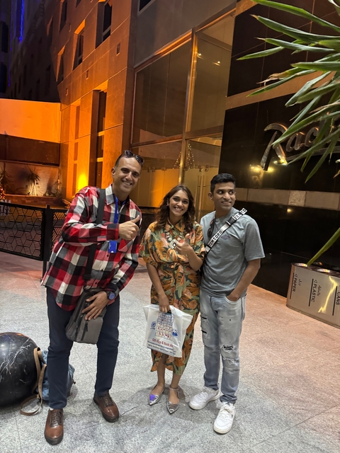       Three people posing indoors with thumbs up
  