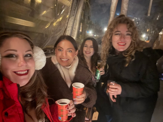 Four people smiling indoors at a social event