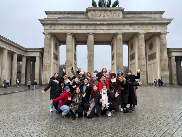 Large group cheering in front of the Brandenburg Gate
