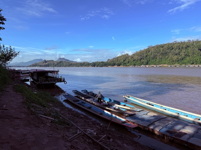 Boats along a riverbank with scenic landscape views.