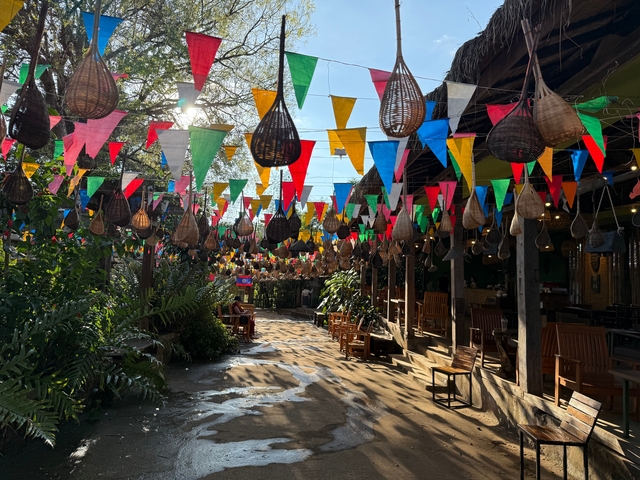       Outdoor area decorated with colorful flags and traditional baskets.
  