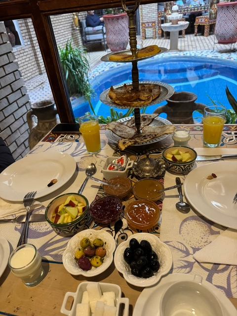       Table with Moroccan breakfast items including bread, jams, and juices.
  