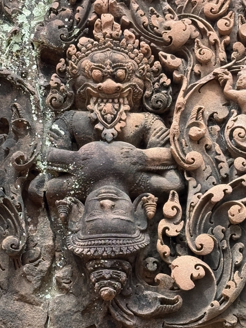 Close-up of intricate carvings of a deity in a temple.