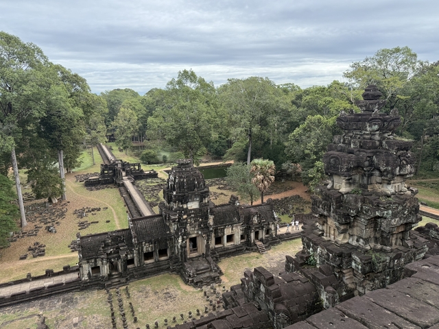 Extensive view of an Angkor temple complex surrounded by trees.