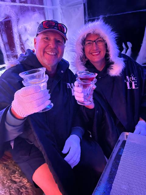 Two people wearing winter attire and holding ice glasses.