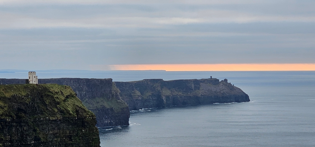 Cliffs of Moher against the ocean under a dramatic sky.