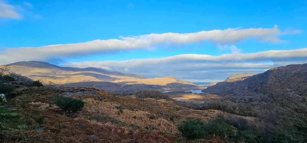 Sweeping landscape view with mountains and clear blue sky.