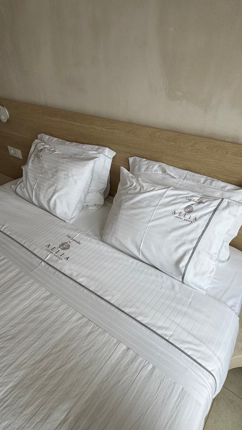       Close-up of pillows with embroidered text on a bed.
  