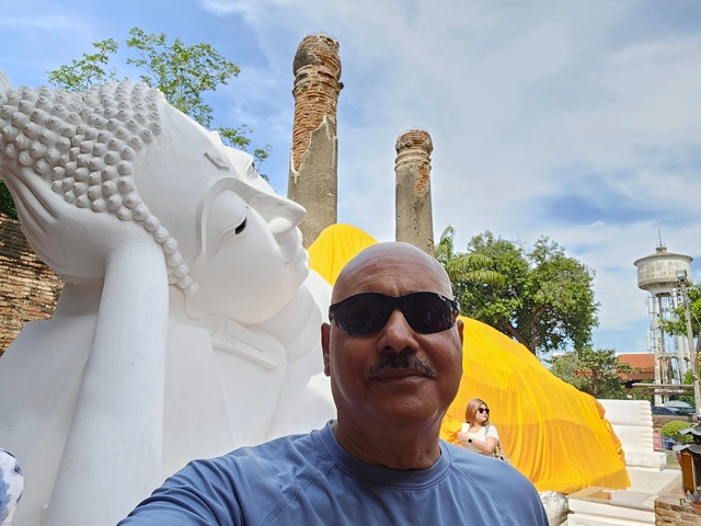 Person in front of a reclining Buddha statue.