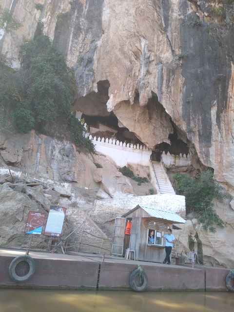       Cave entrance with white decorative fencing.
  