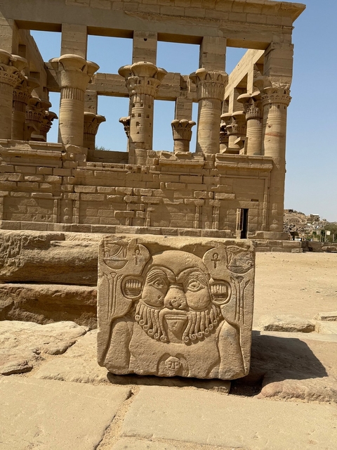 Egyptian temple ruins with carvings and columns in the desert.