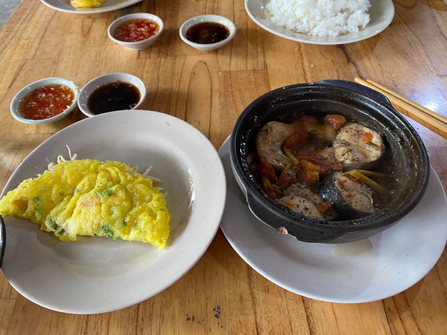 Close-up of a Vietnamese dish with a stuffed pancake and a pot.