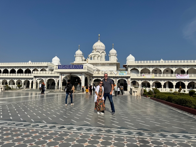       Couple standing in front of a white temple.
  