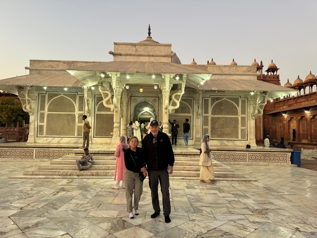       Couple holding hands in front of a historic building.
  
