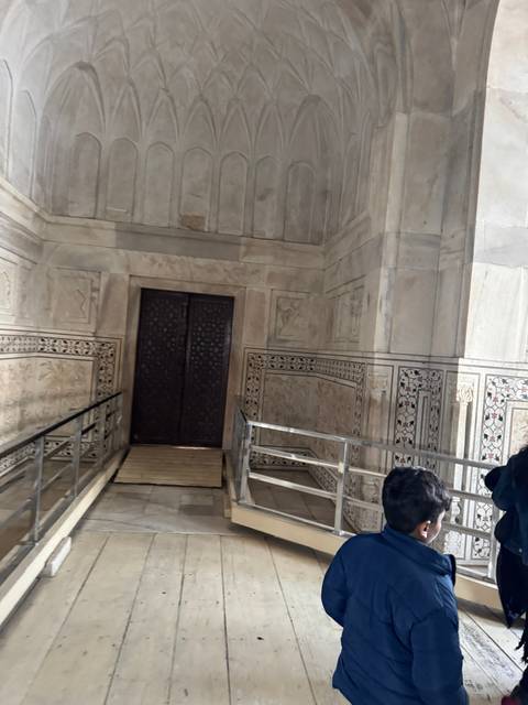       Interior of a marble structure with a railing.
  