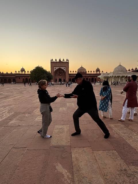       Couple playfully engaged in a courtyard at sunset.
  