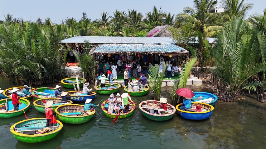 Group of people in colorful round boats on a river.