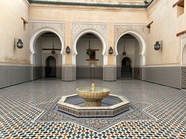       Interior courtyard with ornate arches and a central fountain.
  